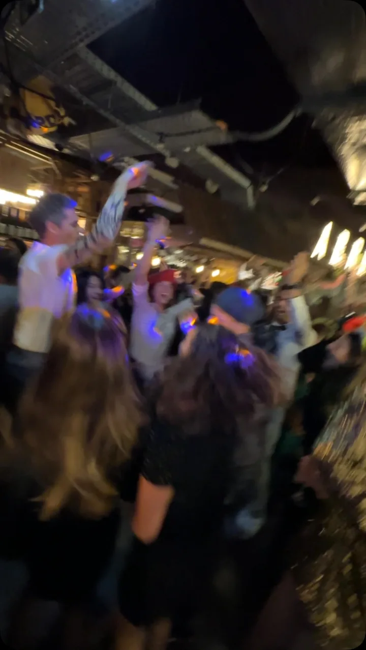 Invités bras levés sur la piste de danse lors d'une soirée à Paris